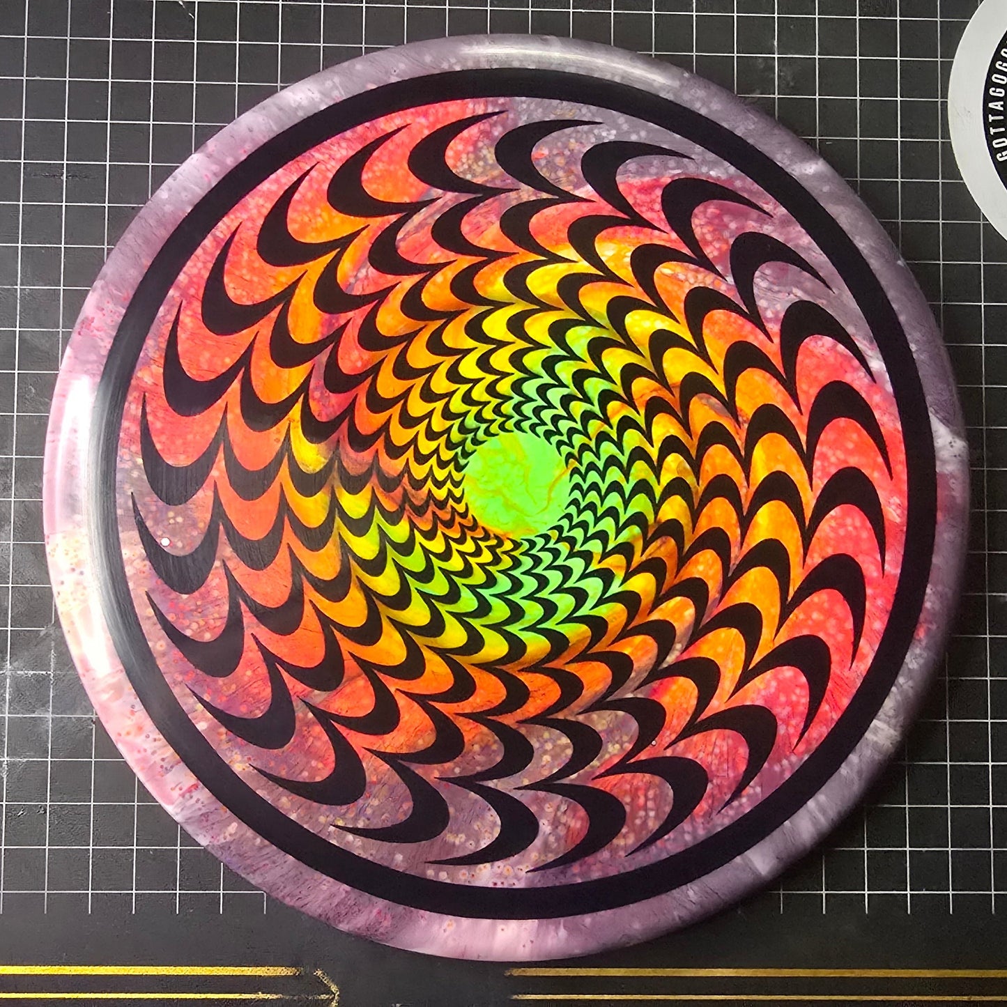 Colorful spiral design on a disc with brand logos in the background