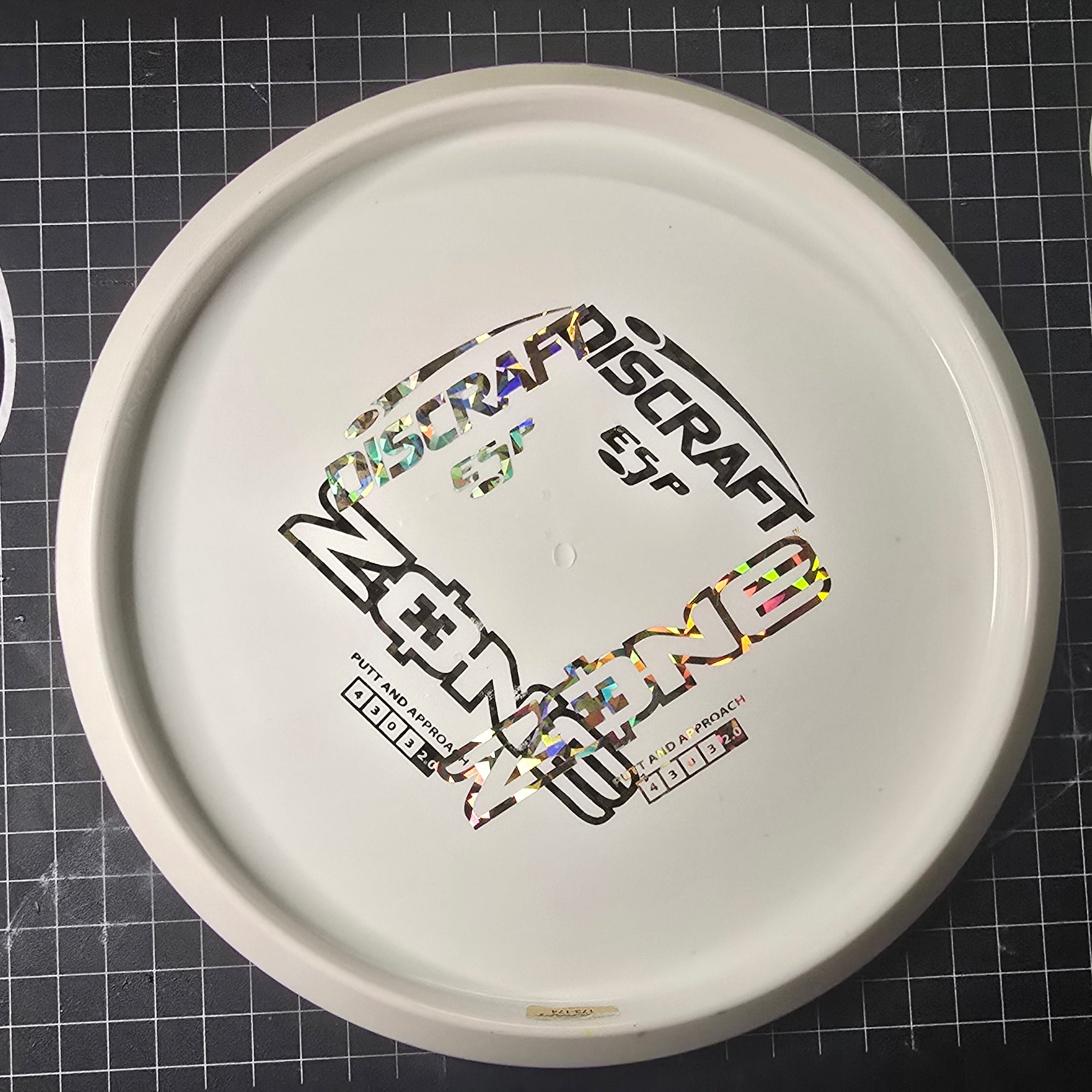 Disc golf disc with branding on a grid background